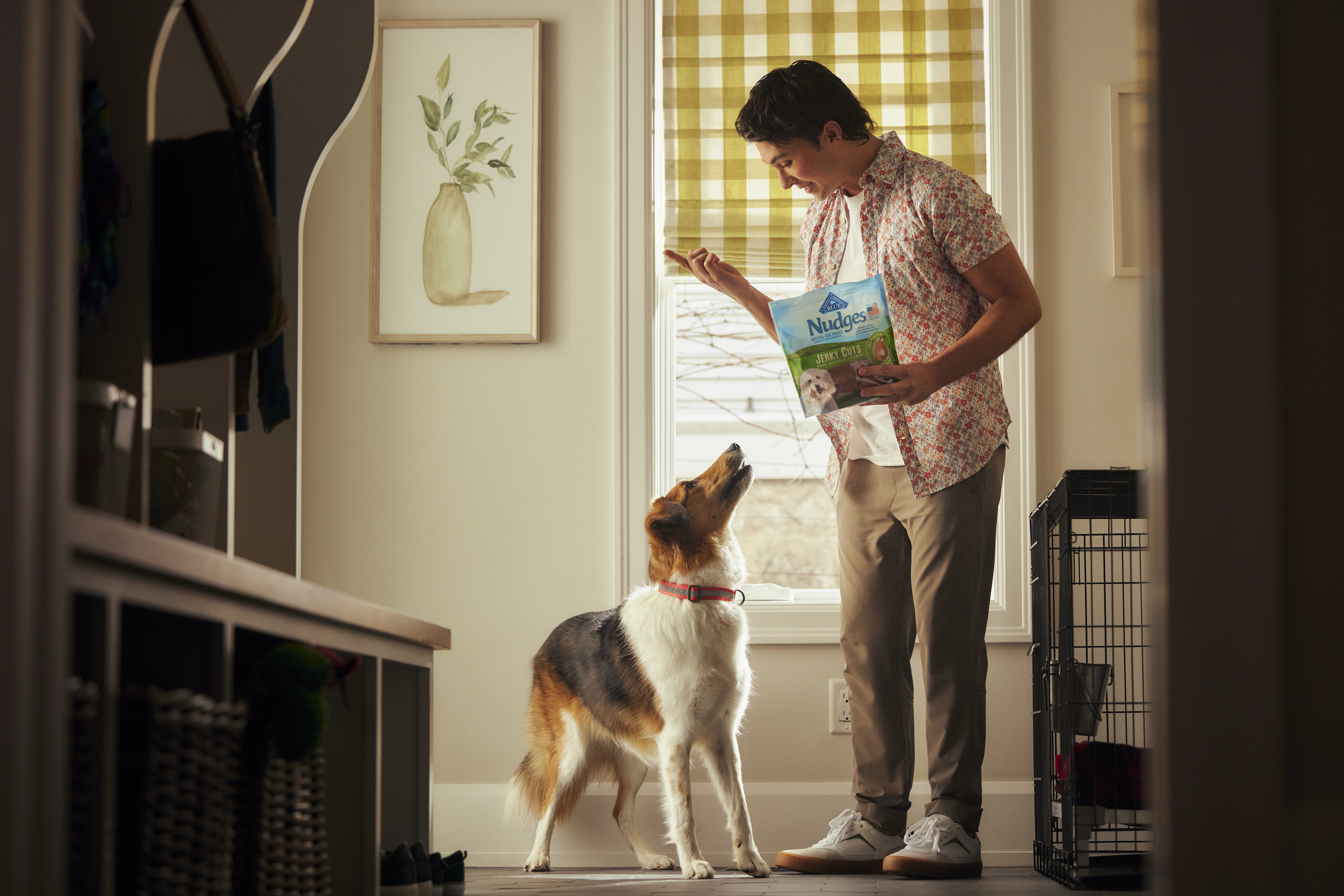 Man holding up a Blue Buffalo treat for his dog